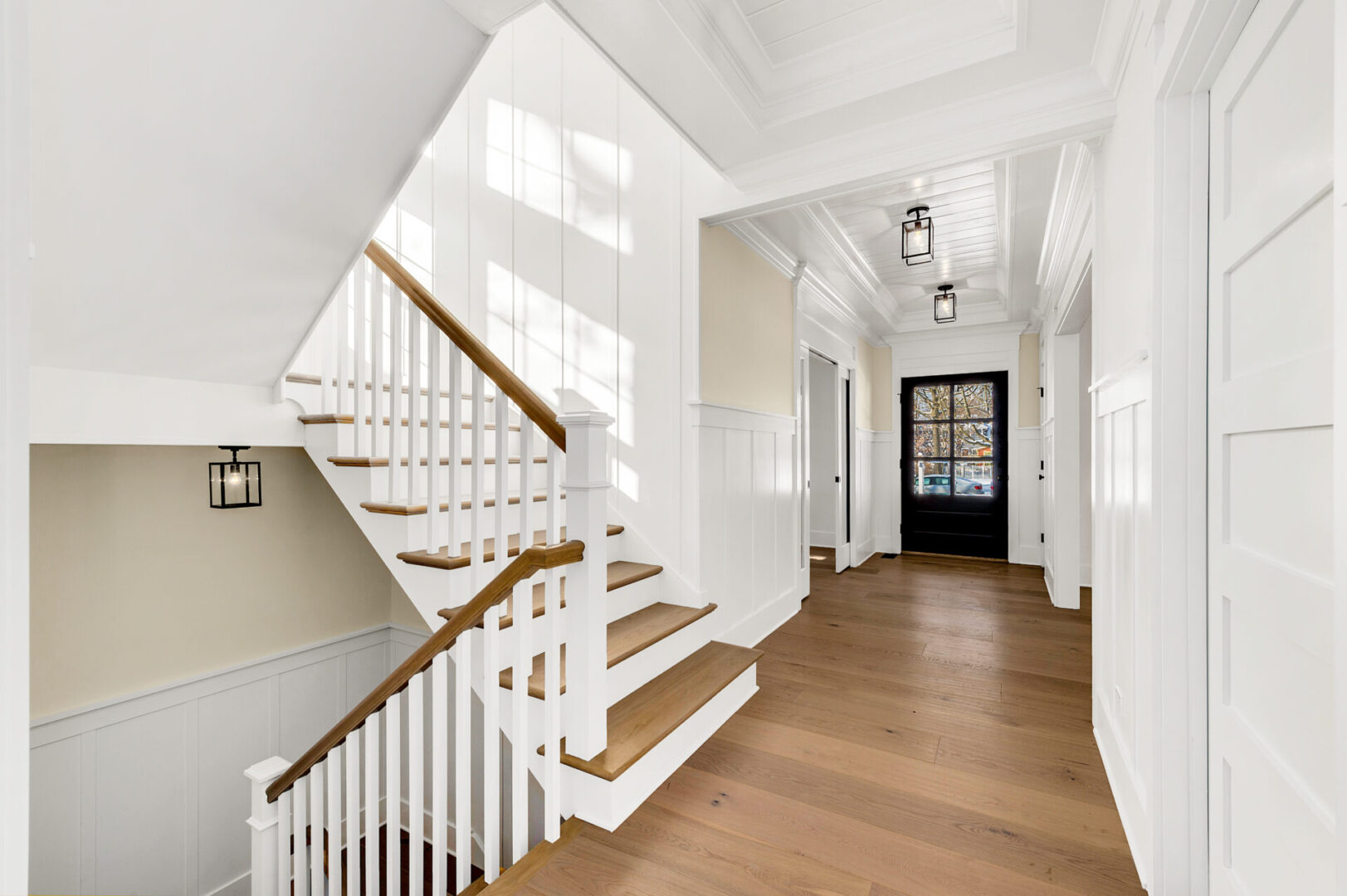 A white staircase with wood steps and wooden handrails.